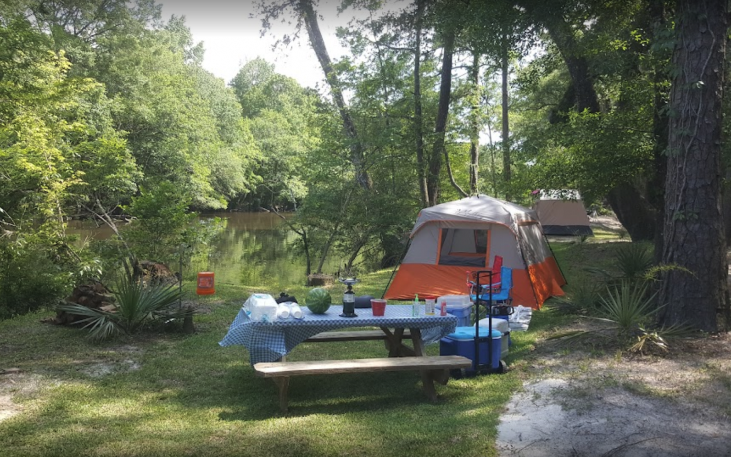 a primitive tent next to a picnic table along Holmes Creek in vernon