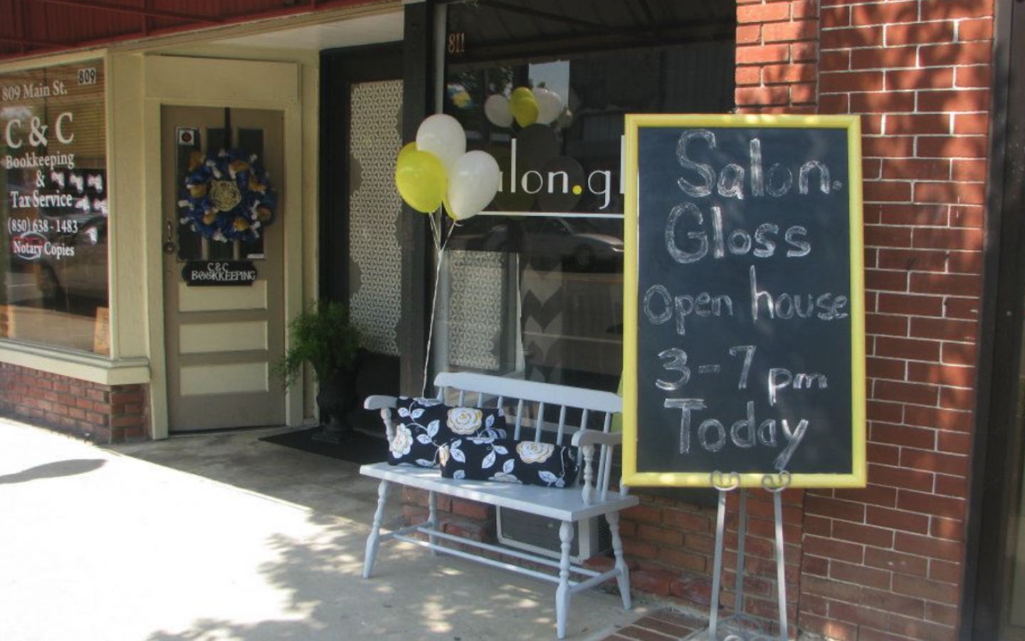 outside brick and wood storefront of salon gloss in chipley