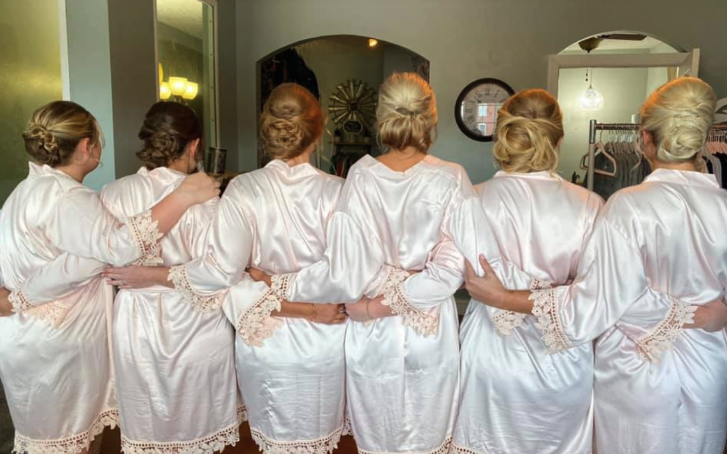 six women in bath robes, facing away from the camera, enjoying a spa day