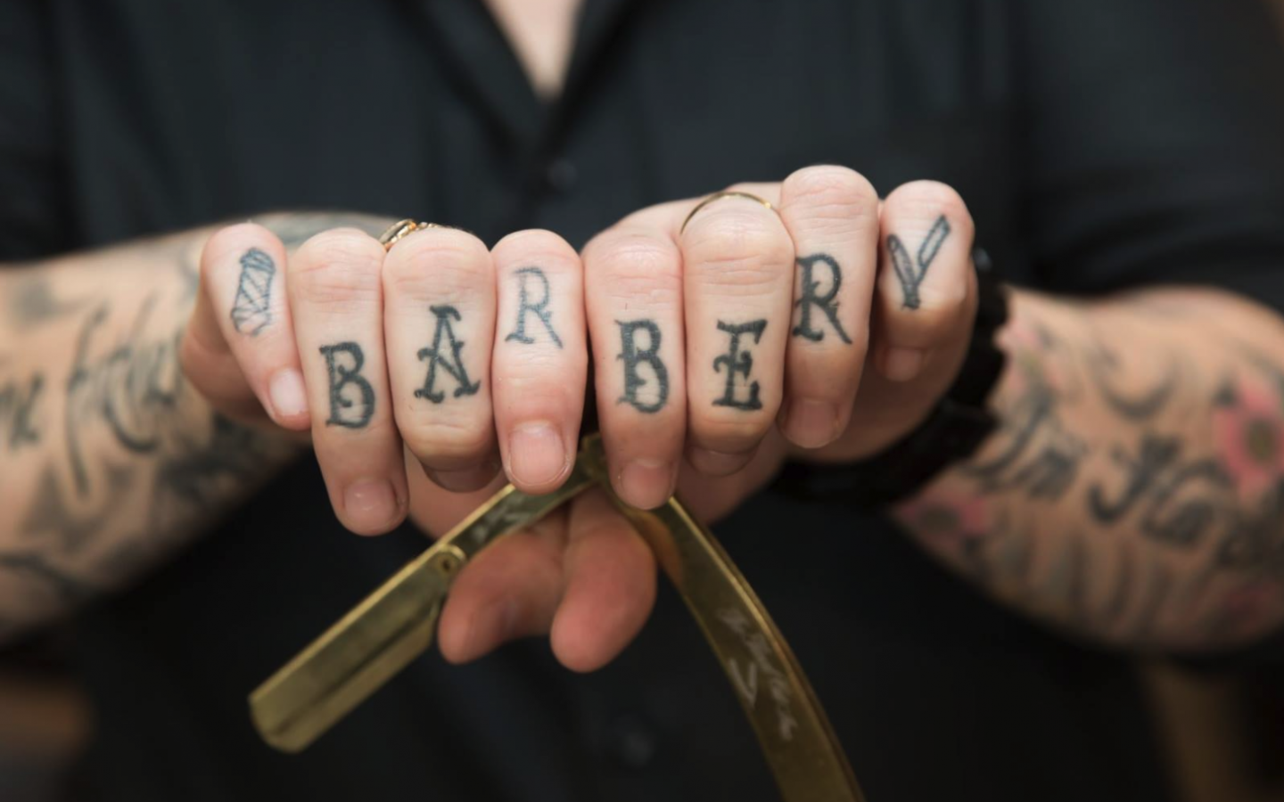 a persons two fists together, grasping a barbers straight razor