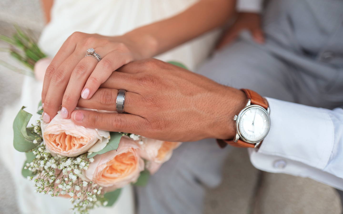 a male and female hand with wedding rings