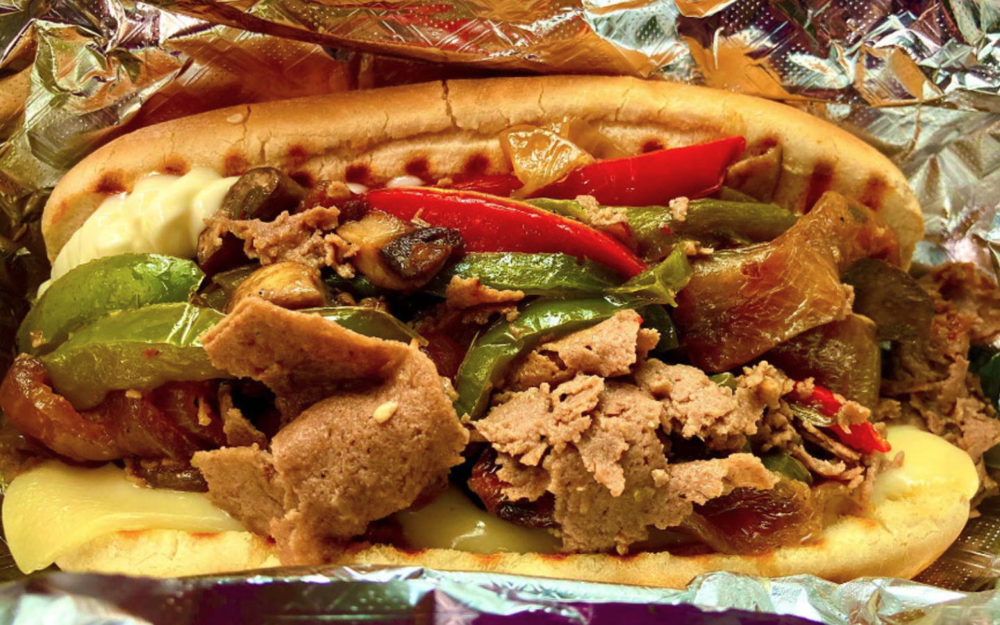 a Philly cheese steak with bell peppers on a 5" bun