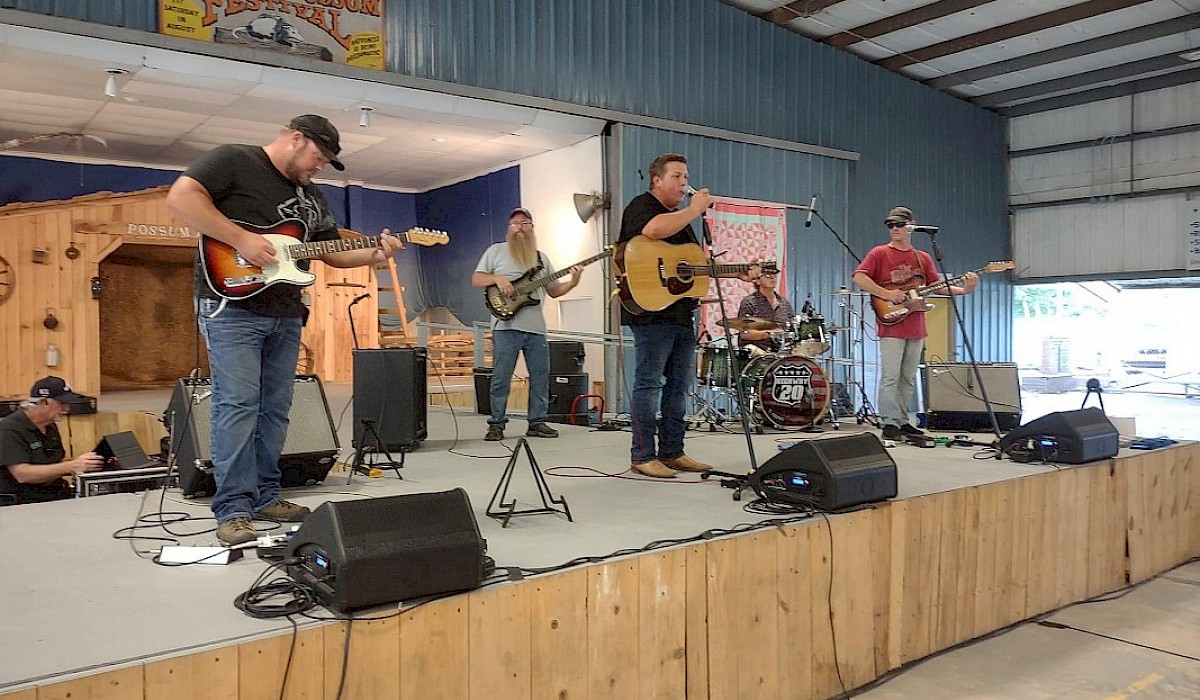 band on stage playing for the crowd under the Possum Palace