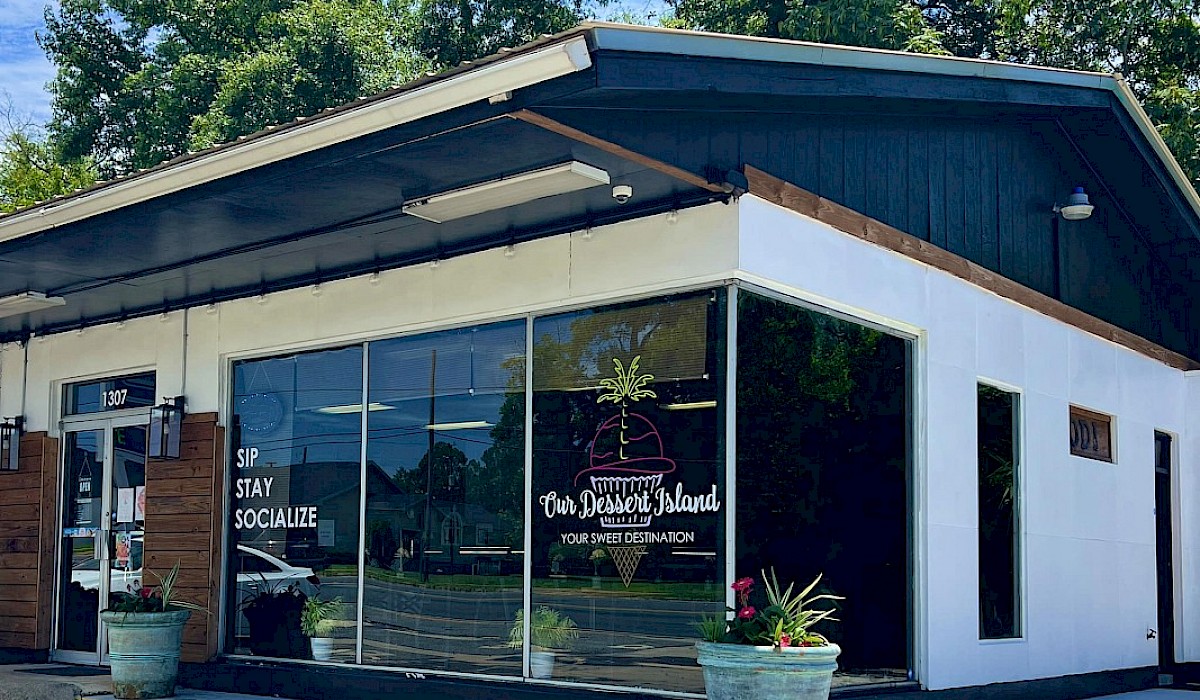 store front of dessert shop with decorative planters on the corner