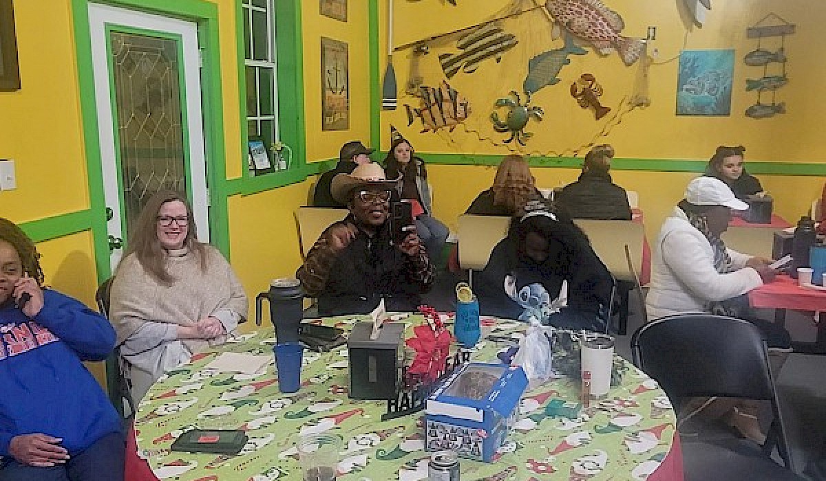 people sitting at a table inside a barn style restaurant eating