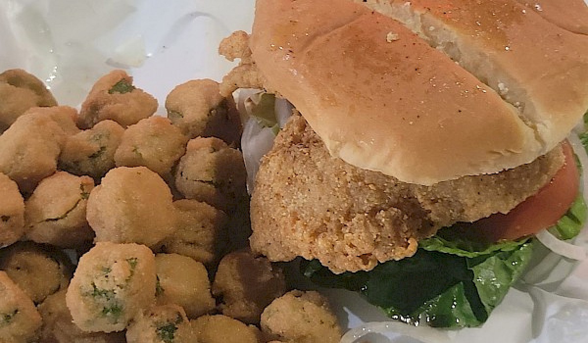 fried fish sandwich with fried okra in a basket at a restaurant