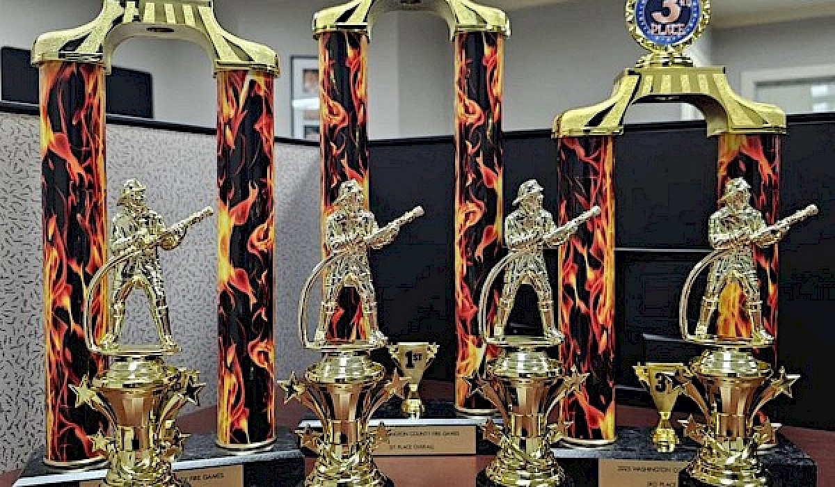 trophies for winners of fire games set on a wooden table in an office