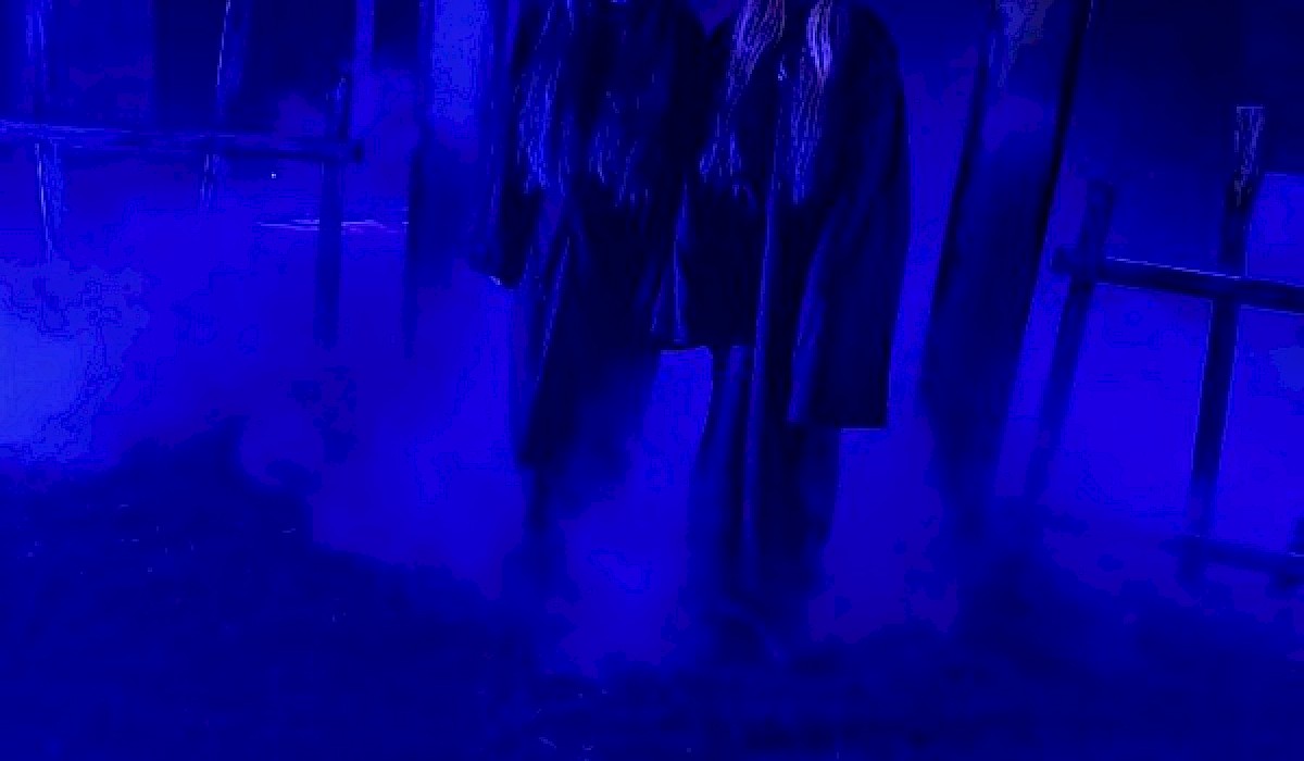 two actors in costumes outside Halloween experience at night